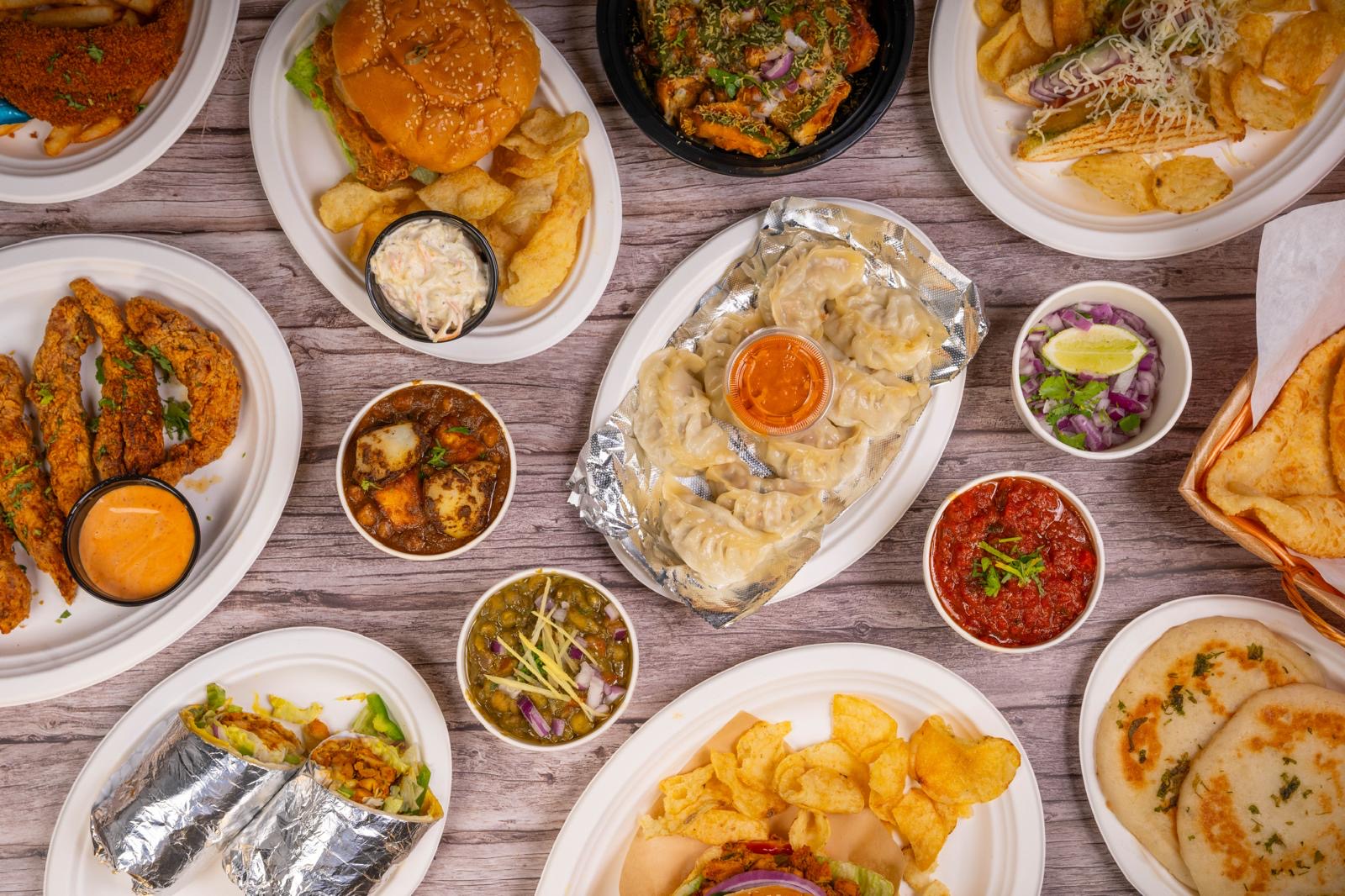 Overhead spread of Kanishka Cuisine's full menu on rustic wood