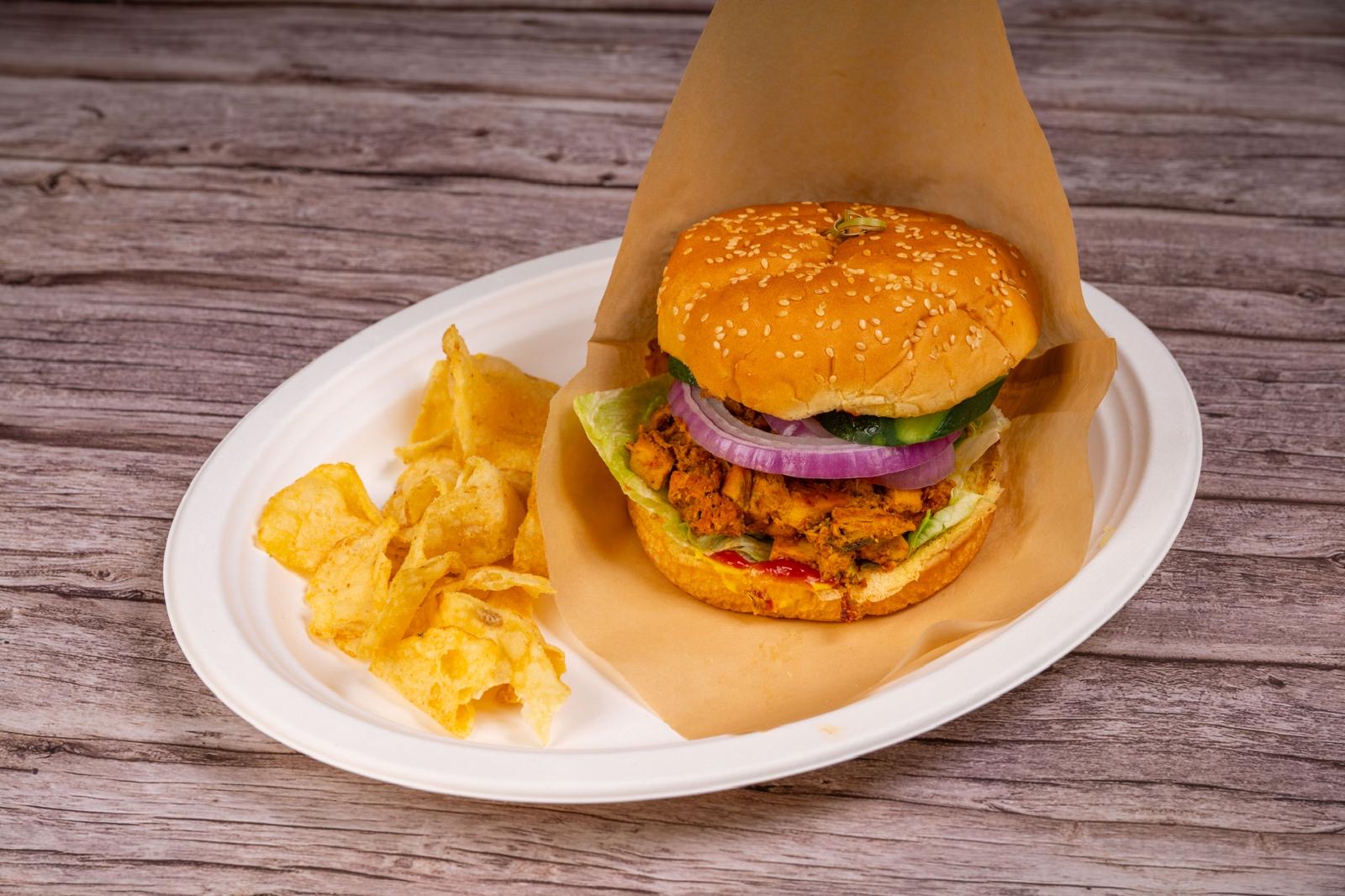 Tandoori chicken sandwich wrapped in parchment with chips